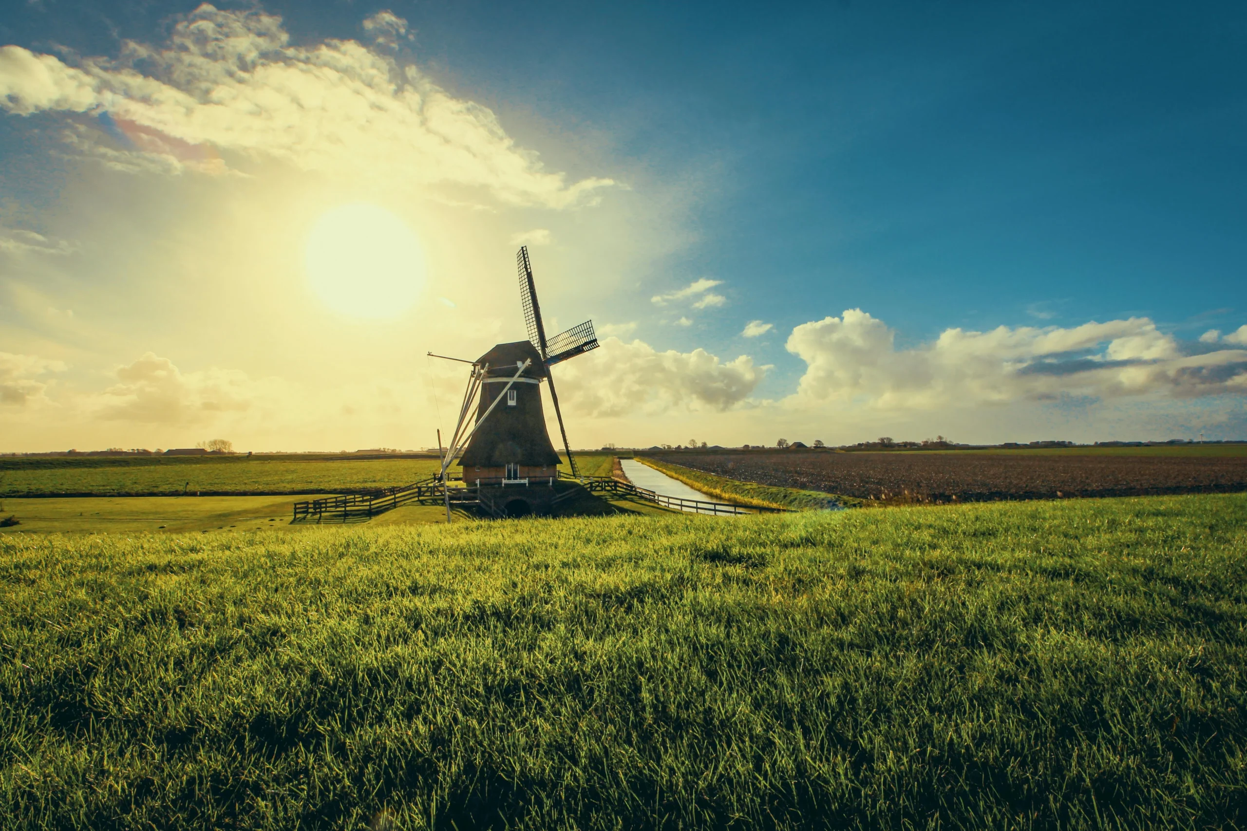 Afbeelding van het Groningse platteland met een windmolen